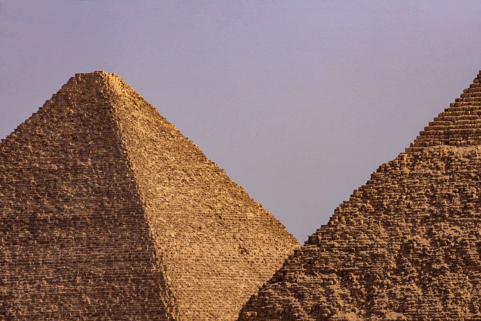 Two Giza pyramids rising side by side under a soft evening sky