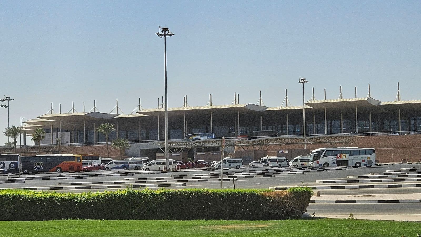 Hurghada International Airport terminal, with transfer coaches and minivans waiting outside