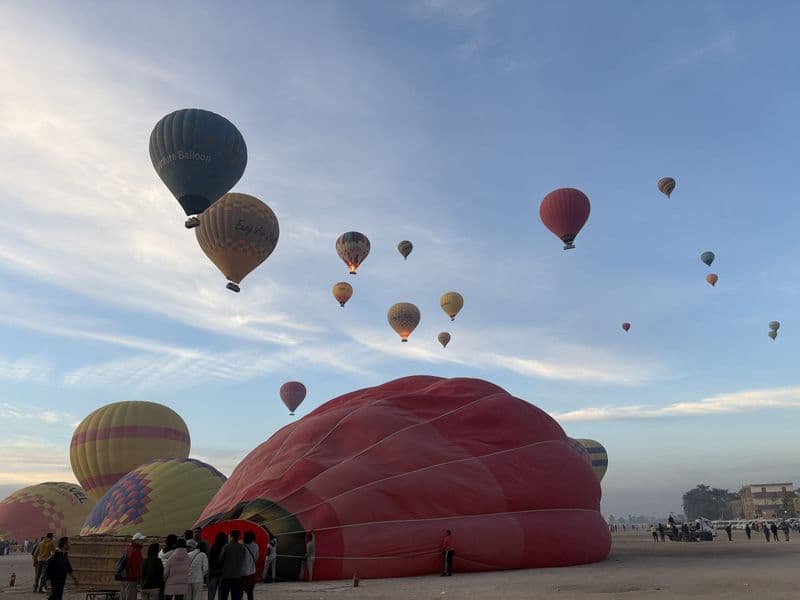 Hot-air balloons rising over Luxor's West Bank at sunrise