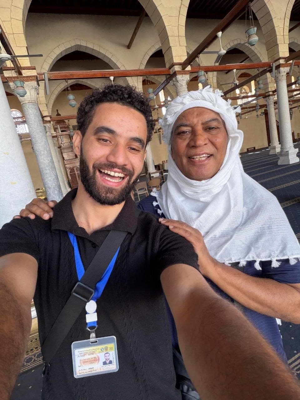 Amr with a traveler under the arches of a historic Cairo mosque