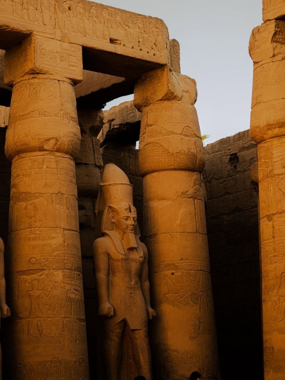Papyrus columns and a standing statue of Ramesses II in Luxor Temple