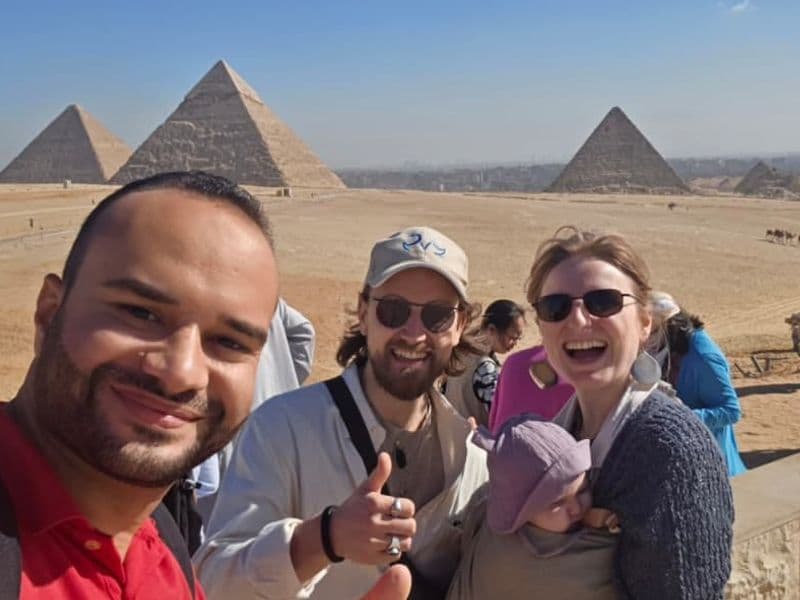 Tarek with a family on the Giza plateau, the three pyramids behind them
