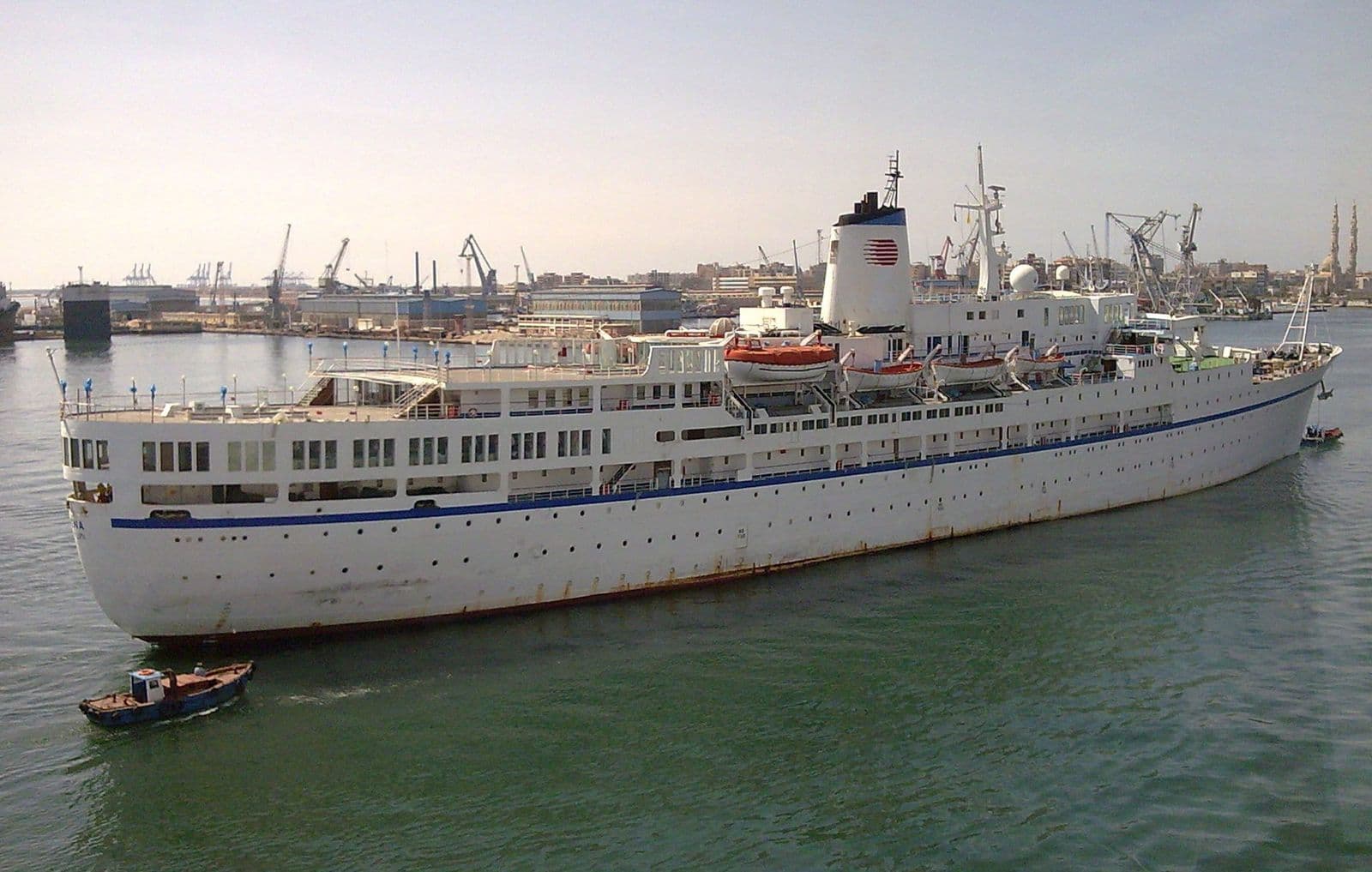 A white passenger ship sailing into the harbour of Port Said