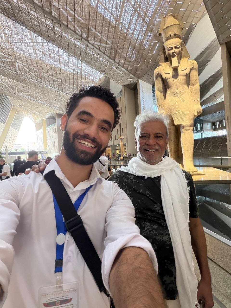 Amr with a traveler by the colossal statue of Ramesses II at the Grand Egyptian Museum