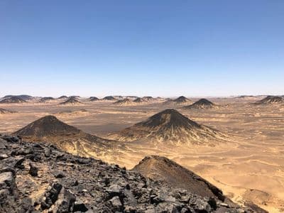 Cone-shaped hills topped with dark stone in the Black Desert