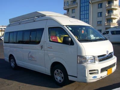 A white Toyota HiAce minivan of the kind used for private transfers in Egypt
