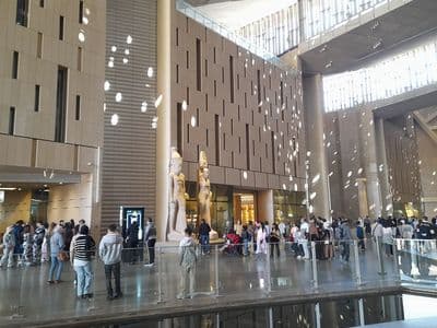 Visitors in the tall atrium of the Grand Egyptian Museum