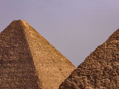 Two Giza pyramids rising side by side under a soft evening sky