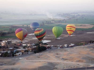 Colourful hot-air balloons over the green fields of Luxor's West Bank