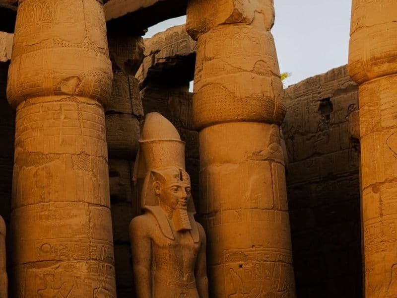 Papyrus columns and a standing statue of Ramesses II in Luxor Temple